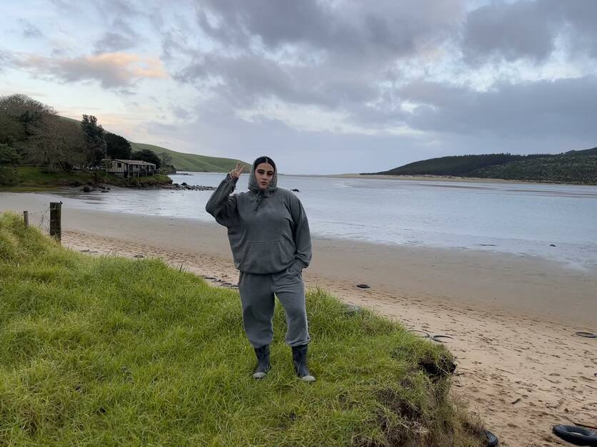 Person standing on grass in an estuary in New Zealand