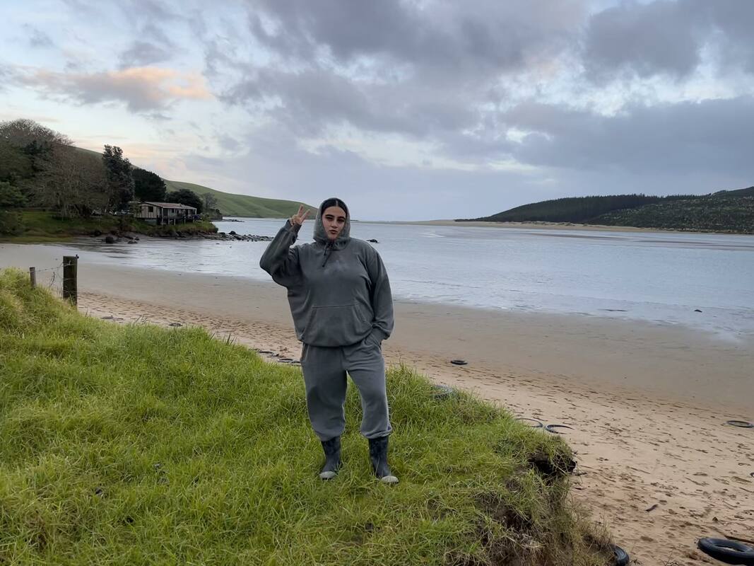 Person standing on grass in an estuary in New Zealand